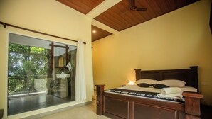 Ein Schlafzimmer mit einer großen Glasschiebetür, die auf einen Balkon führt, einem hölzernen Bett mit Kopfteil und einem Deckenventilator.