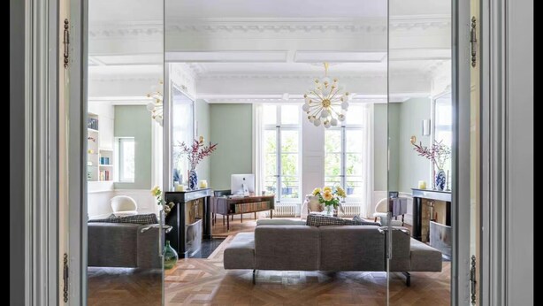 Un salón amplio con un sofá grande, una zona de comedor y una chimenea.