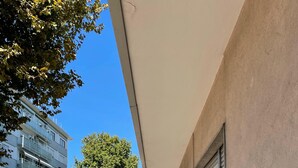 A balcony with a view of a tram line, a tree, and adjacent buildings. - Venetian Breeze (Mestre)
