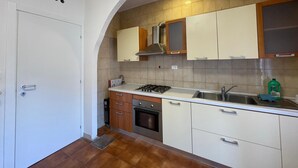 A kitchen with a stove, oven, sink, and cabinets. - Venetian Breeze (Mestre)