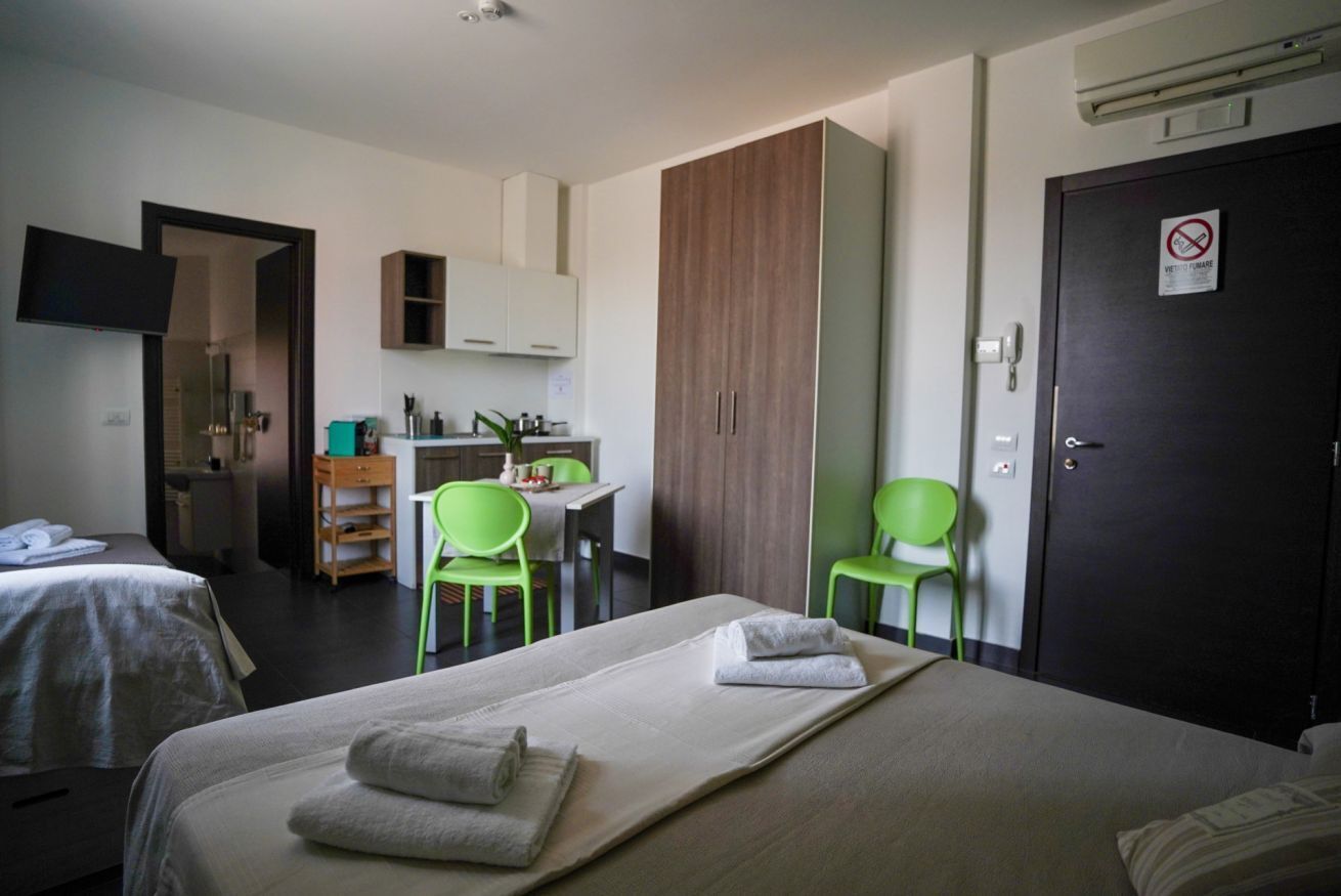 Een hotelkamer met twee bedden, een bureau, een stoel en een kledingkast.