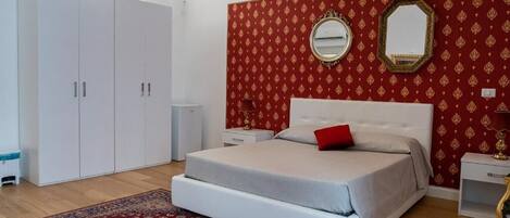 Un dormitorio con cama, armario, espejo y pared con diseño.