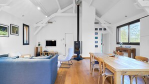 Un salon moderne comprenant un canapé, une table à manger et des chaises, un téléviseur et une cheminée.