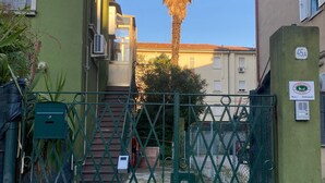 A gated entrance with a palm tree in the background. - Venetian Nexus (Mestre)