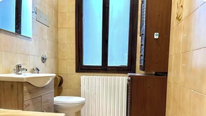 A bathroom with a bathtub, sink, toilet, and a window. - Venetian Nexus (Mestre)