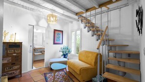 Un intérieur moderne avec un escalier, un canapé, une petite table et un meuble.
