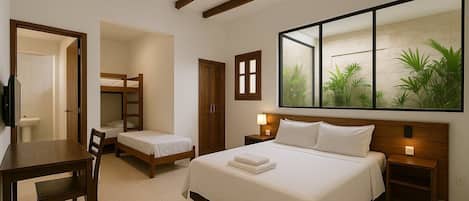 Habitación de hotel con una cama grande, un escritorio con una silla, una cama nido pequeña y un armario.