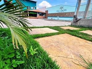 A swimming pool area with a building labeled 'VILA LENCOS SPORT & RESORT' and a paved walkway. - Pousada Vila Lençóis e Sport (Barreirinhas)