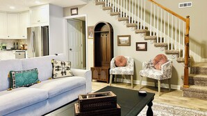 A living room with a sofa, two armchairs, a coffee table, and a staircase. - La Casita- Trailside Retreat in Collegedale (Collegedale)