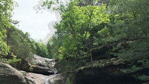 A natural landscape with a waterfall and a calm river.