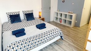 A neatly arranged bedroom with a patterned bedspread, two pillows, and a bedside table with a lamp. - The Family House, spacious with outdoor area, children's play area, wifi and parking. (Cormicy)