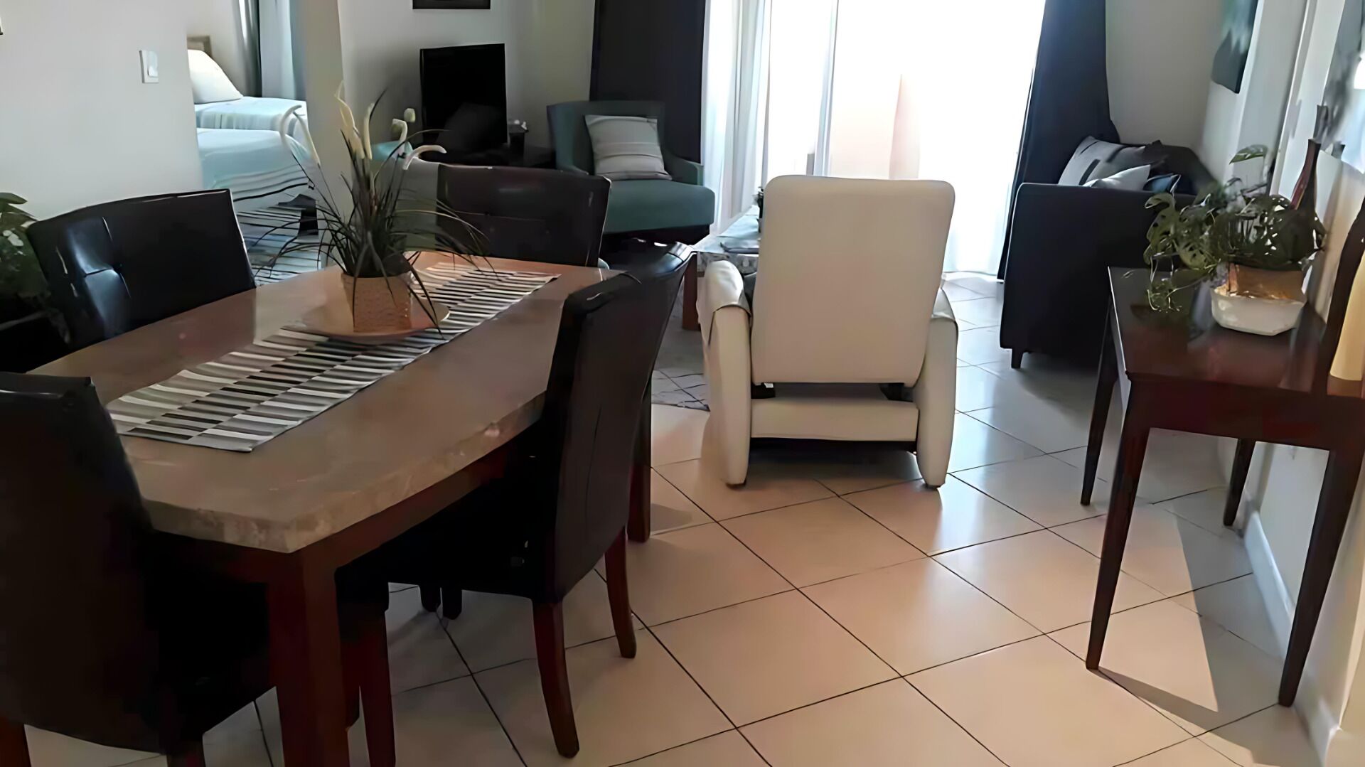 Ein Essbereich mit einem Holztisch, Stühlen und einem Blumentopf.