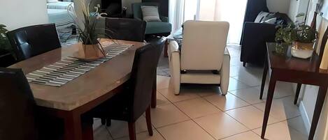 Ein Essbereich mit einem Holztisch, Stühlen und einem Blumentopf.