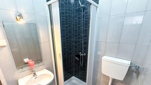 A bathroom with a shower, sink, toilet, and a mirror. - Residencial Boavistense by Umbral (Odemira)