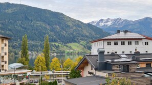 A hotel with a view of a lake and mountains, featuring a modern design with multiple floors and a flat roof. - Chalet Skilift - Lake View Incl Summer Card (Zell am See)