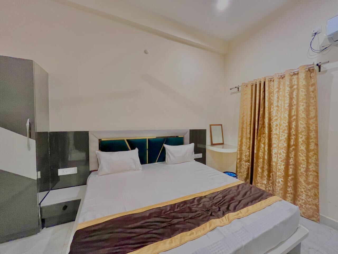 Una habitación de hotel con una cama, mesita de noche y armario.