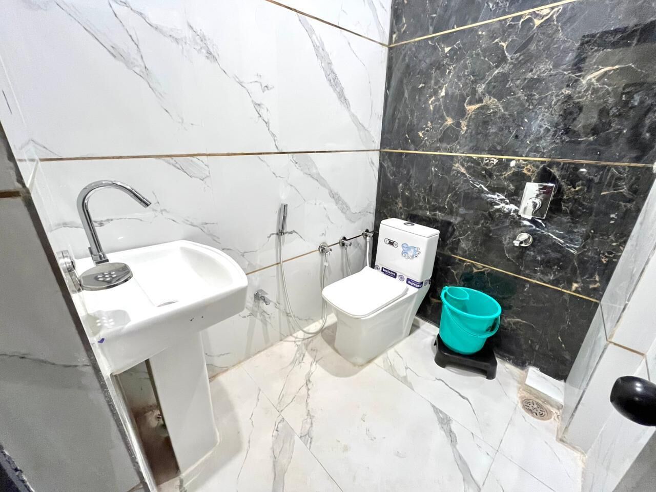 Un baño con lavamanos blanco, inodoro y ducha.