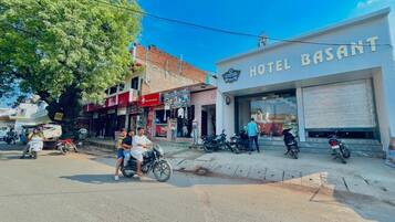 A street view with a building labeled "HOTEL BASANT" and a tree in the foreground.
