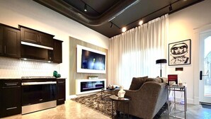 Una sala de estar moderna con un sofá, un televisor de pantalla plana y una chimenea.