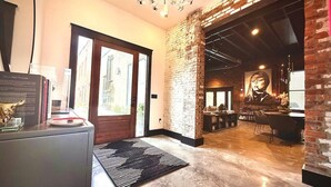 Un interior moderno con pared de ladrillo, una lámpara de araña y una zona de bar.