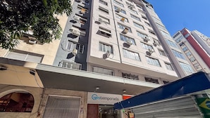 A hotel entrance with a sign reading 'yestemporada' and a closed shop with a blue signboard. - Temporada Prime - Praia (Rio de Janeiro)
