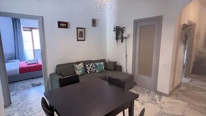 A dining area with a marble floor, a dark wooden table, and four chairs. - Spazioso 3 Camere con Balcone AC Vaticano (Roma)