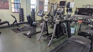 Uma academia com diversos equipamentos de exercício, incluindo esteiras, elípticos e aparelhos de musculação.