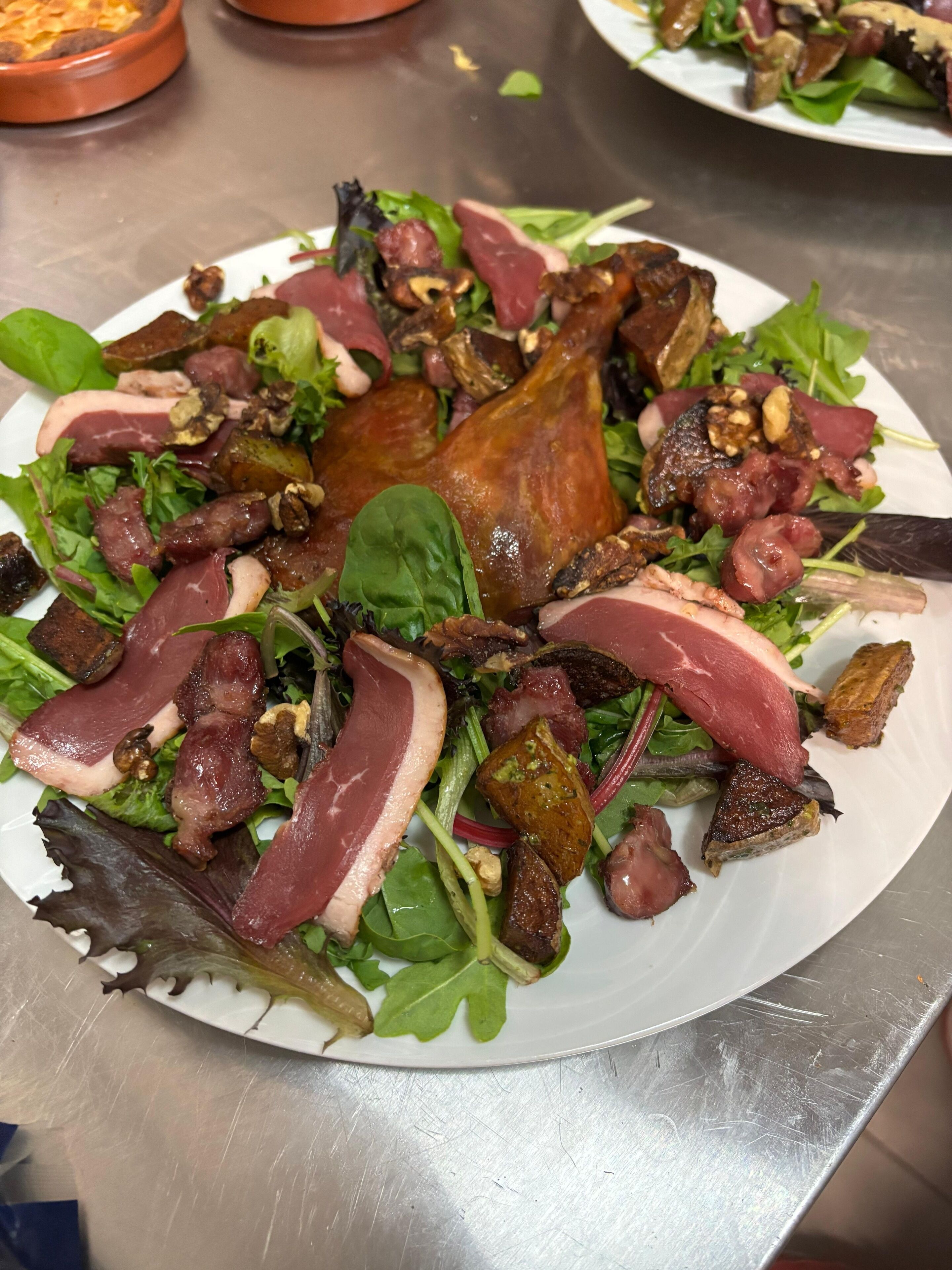 A plate of food with various meats and greens.