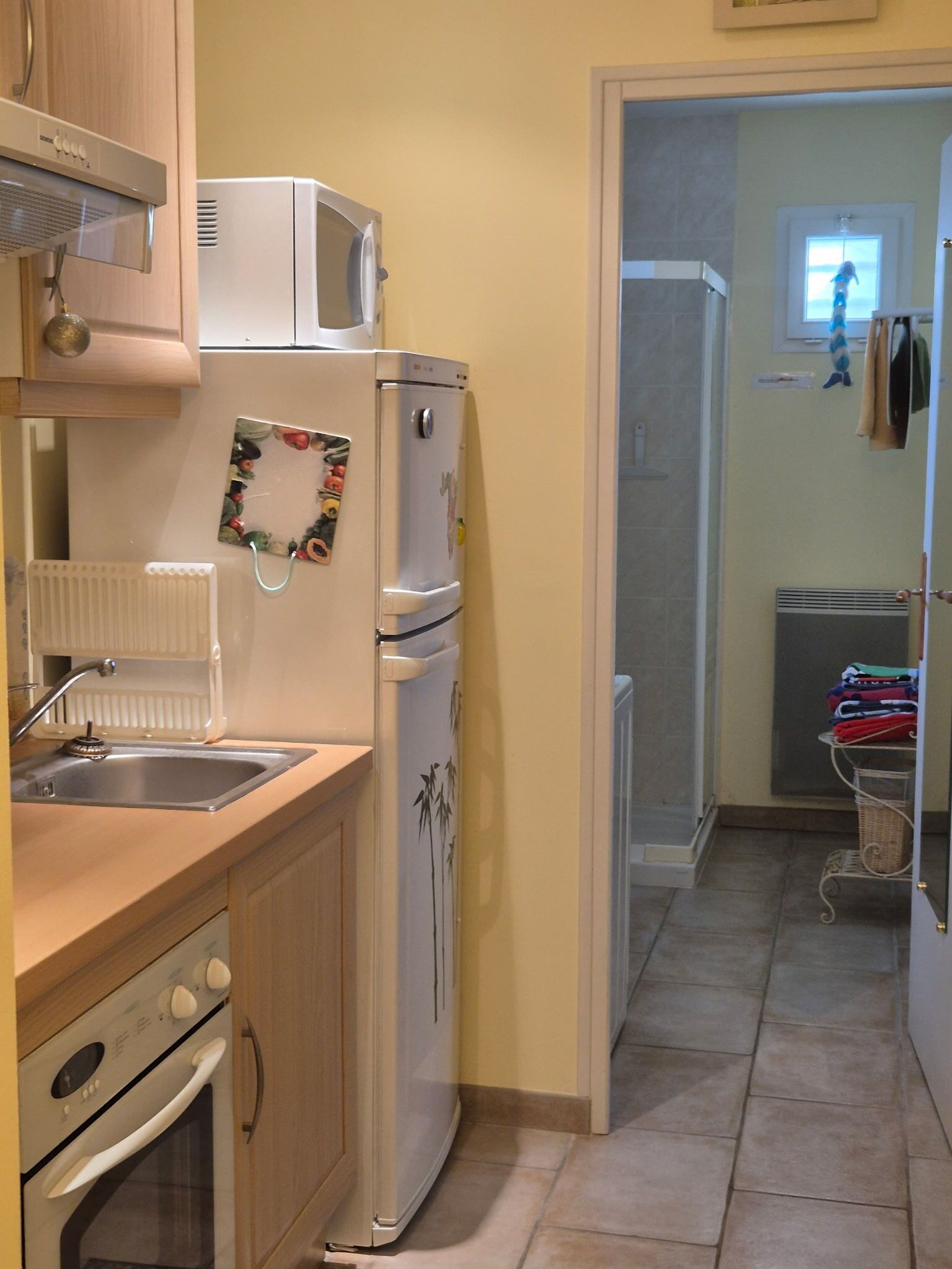 A compact kitchen with a refrigerator, stove, and microwave.