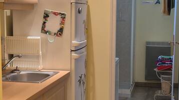 A compact kitchen with a refrigerator, stove, and microwave.