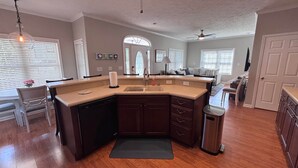 A kitchen with a dishwasher, a sink, and a trash can.