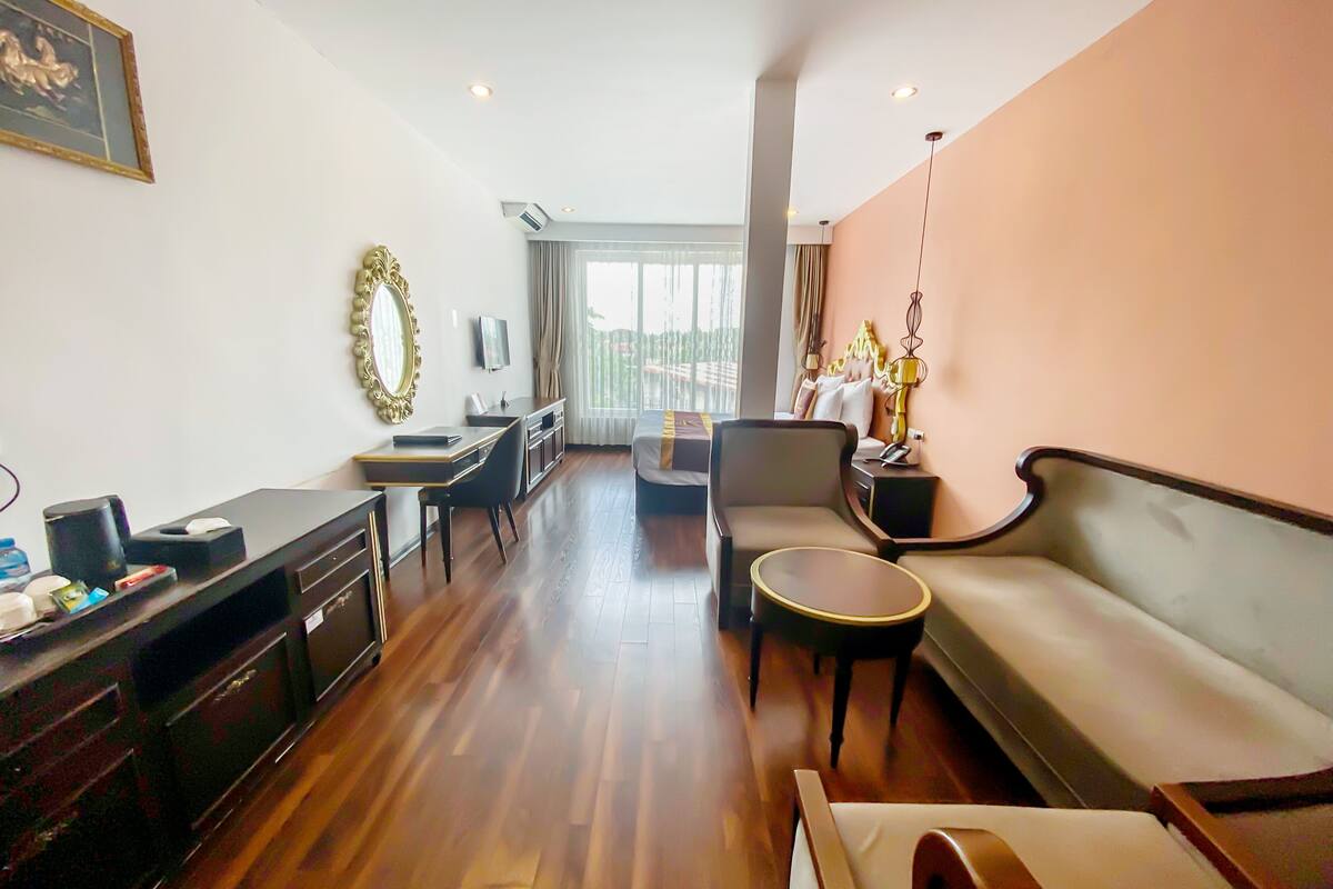 A spacious living area with a sofa, a dining table, and a TV.