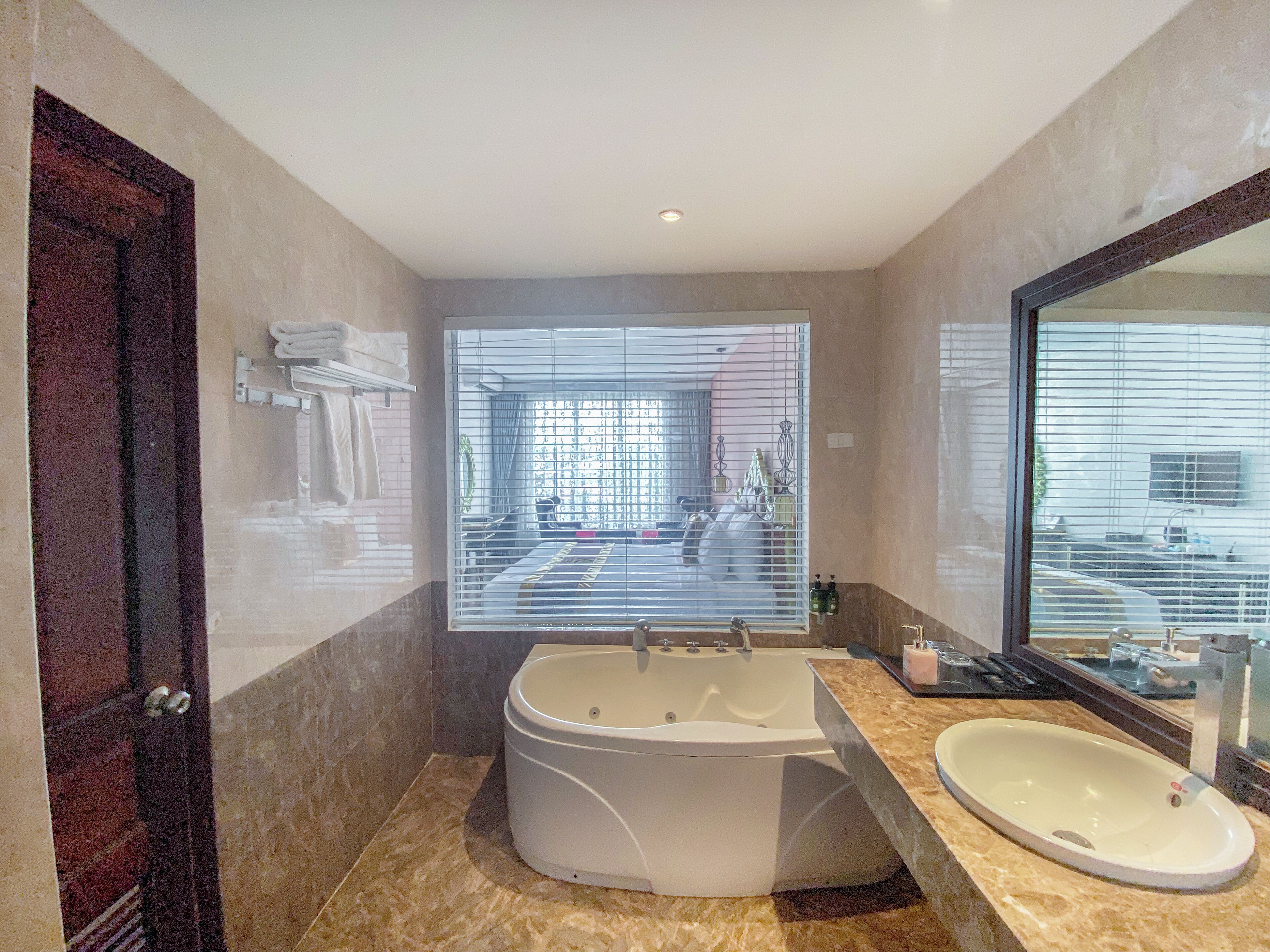 A modern bathroom with a large bathtub, a sink, and a large mirror.