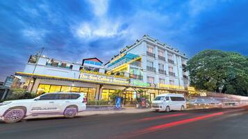 Un hotel de varios pisos con un llamativo letrero de 'Heineken', un 'Sun Coffee & Restaurant' en la planta baja y un letrero de 'Xaysomboun Hotel & Spa'.