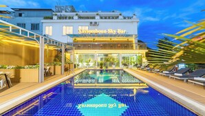 Ein Hotel mit Pool, Außenbereich und gut beleuchtetem Eingang.