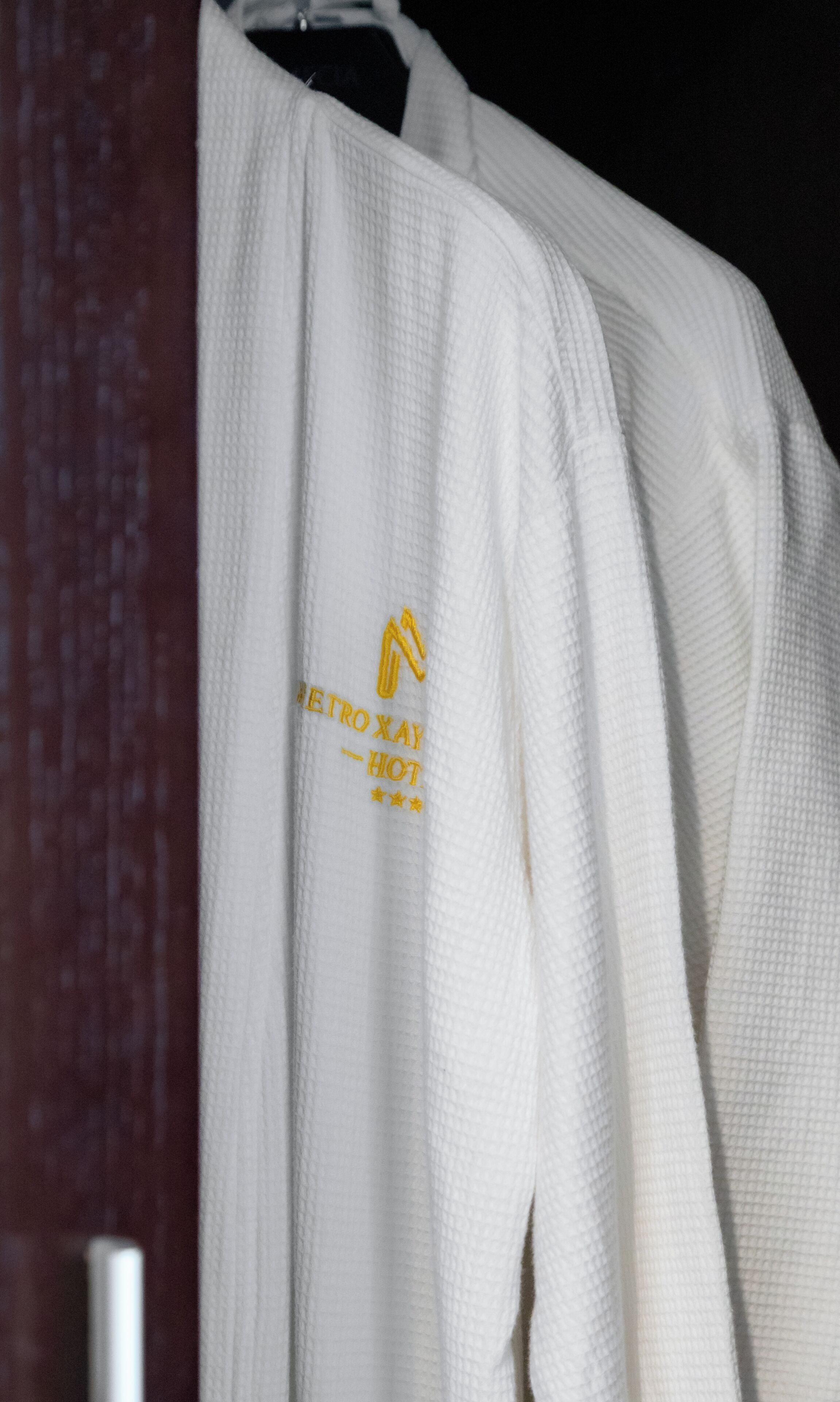 A white garment with a logo and text on the sleeve.