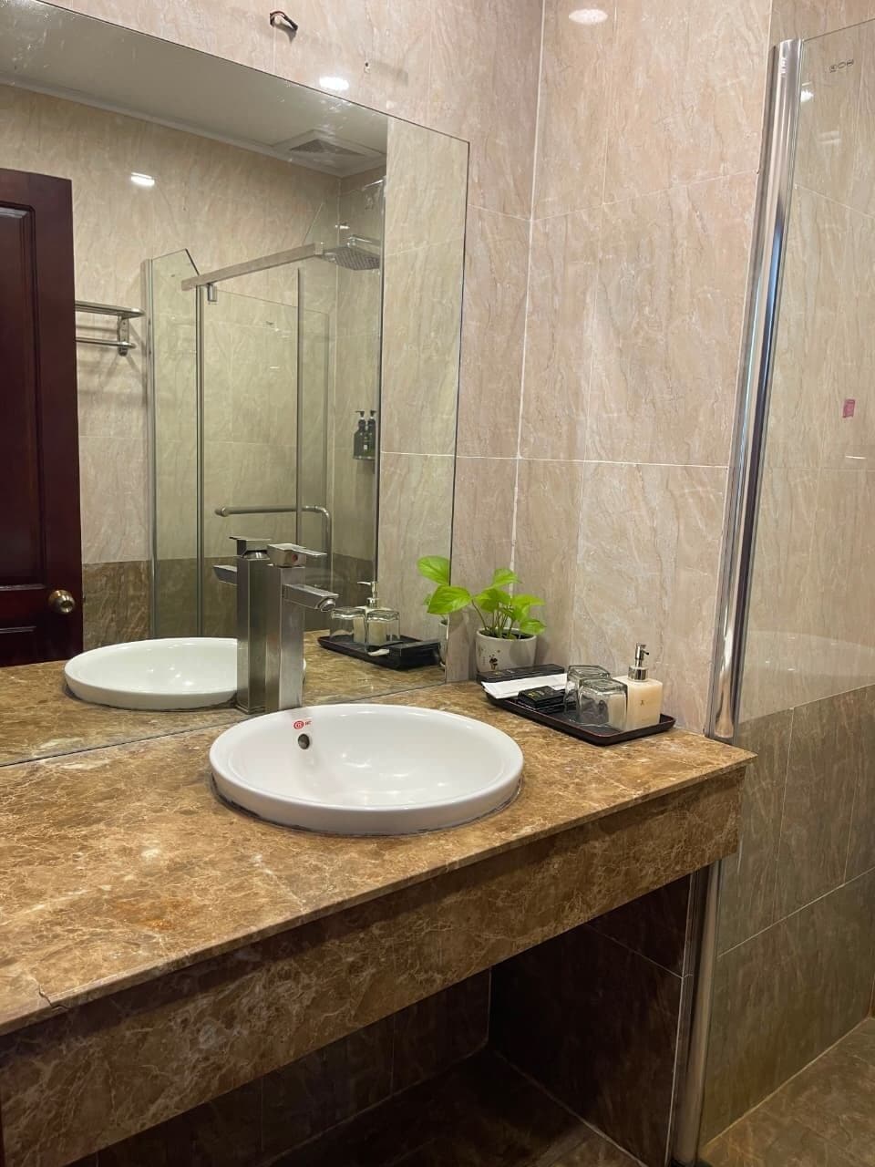A bathroom with two sinks, a shower, and a mirror.