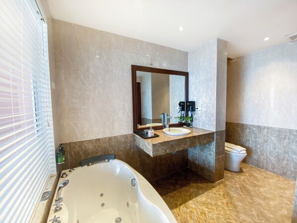 Une salle de bain moderne avec une baignoire sur pieds, un lavabo avec un miroir au-dessus et des toilettes.