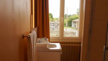 Un baño con ventana, lavamanos y perchero.