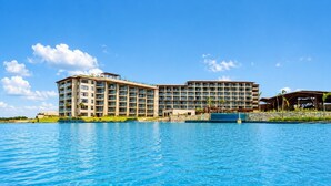 Un hotel grande con varios pisos, piscina y un área exterior techada.