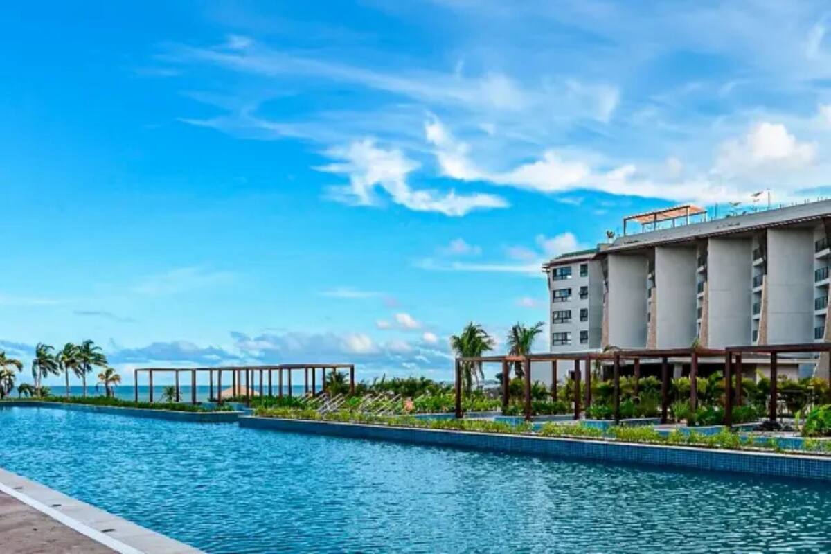 Una piscina con vistas a un hotel y al océano.