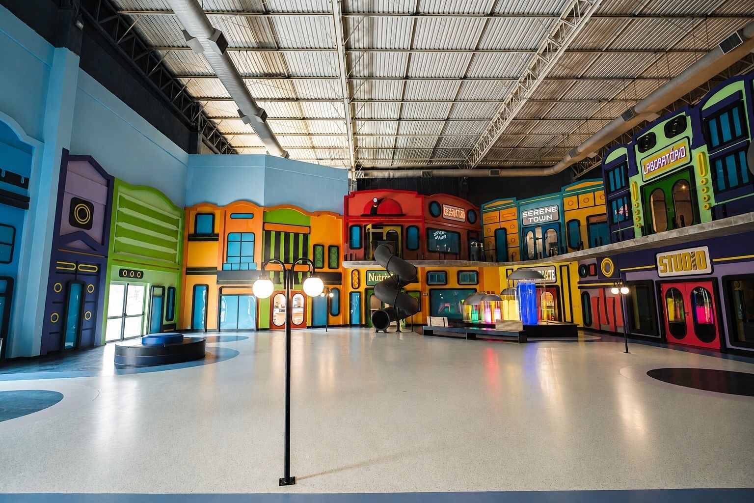 A colorful indoor space with various themed areas, including a 'Serene Town' and 'Studio 10'.