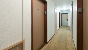 A hallway with wooden doors, a vent, and a tiled floor. - Renovated Studio with Mountain View, Near Méribel Ski Lifts (Brides les Bains)