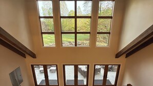 Un vaste salon doté d’un haut plafond, de grandes fenêtres et d’un lustre.
