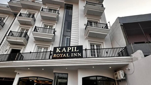 A building with a sign reading "Kapil Royal Inn" and two motorcycles parked in front. - Hotel Kapil Royal Inn (Haridwar)