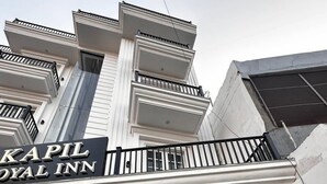 The exterior of Kapil Royal Inn with a prominent sign, a glass entrance, and a balcony with railings. - Hotel Kapil Royal Inn (Haridwar)