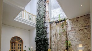 Ein geräumiger Innenhof mit hoher Decke, einem dekorativen gelben Geländer und fliesenbelagtem Boden.
