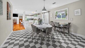 A dining area with a checkered floor, a round table, and modern chairs. - Retro Style River house in Milton Florida on Beautiful Black Water River.  (Milton)