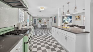 A kitchen with a checkered floor, white cabinets, a green stove, and pendant lights. - Retro Style River house in Milton Florida on Beautiful Black Water River.  (Milton)