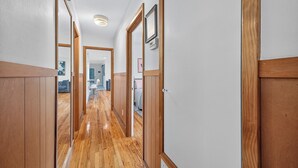 A hallway with wooden paneling, a polished wooden floor, and a ceiling light. - Retro Style River house in Milton Florida on Beautiful Black Water River.  (Milton)